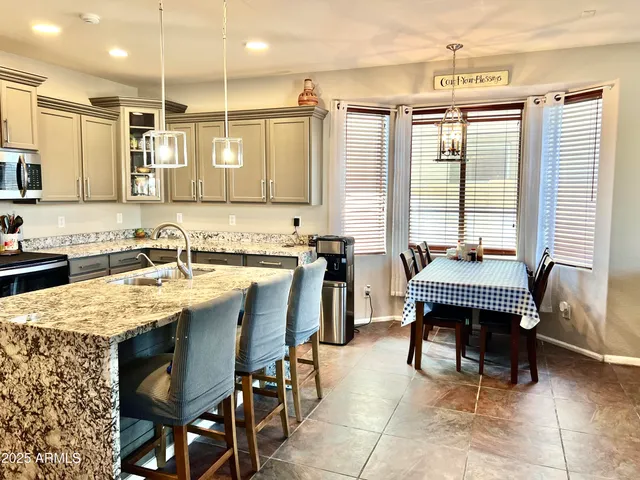a large kitchen with kitchen island a dining table and chairs
