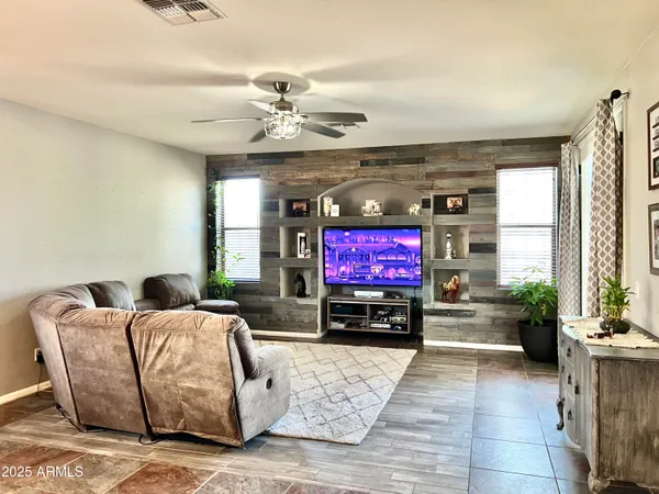 a living room with furniture a flat screen tv and a fireplace