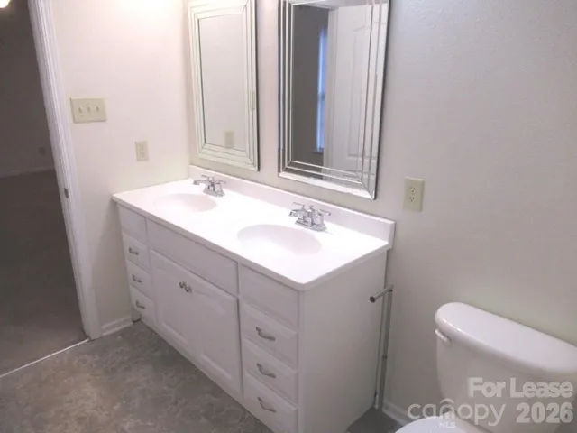 a bathroom with a sink toilet and mirror