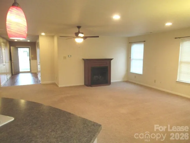a view of an empty room with a fireplace and a window