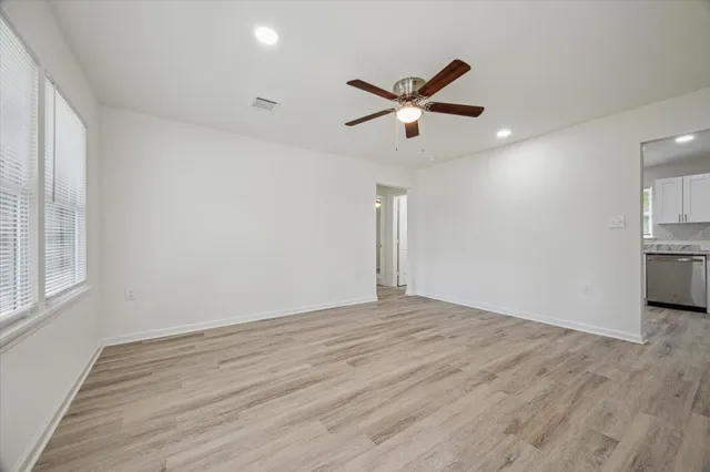 a view of empty room with wooden floor and window