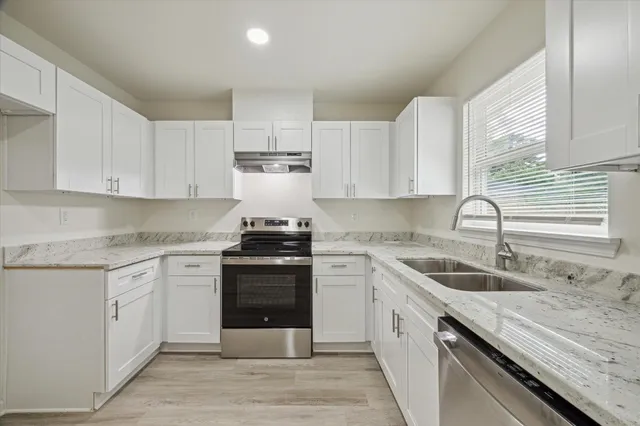 a kitchen with a sink stove and cabinets
