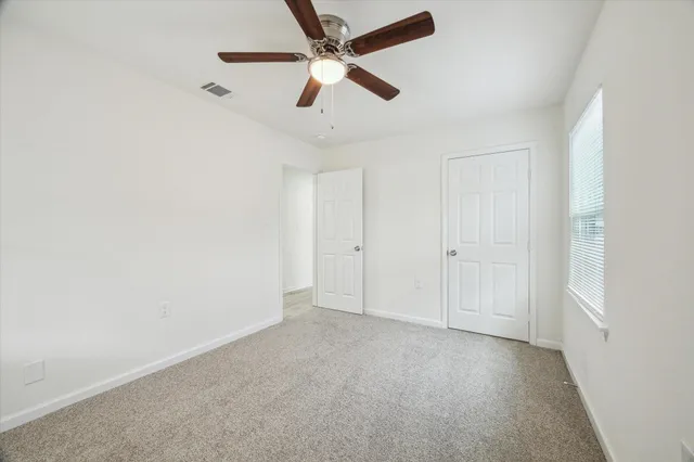 an empty room with chandelier fan