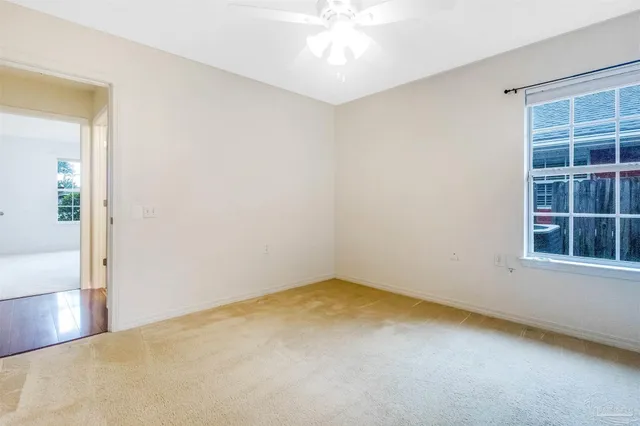 a view of a room with wooden floor and a ceiling fan