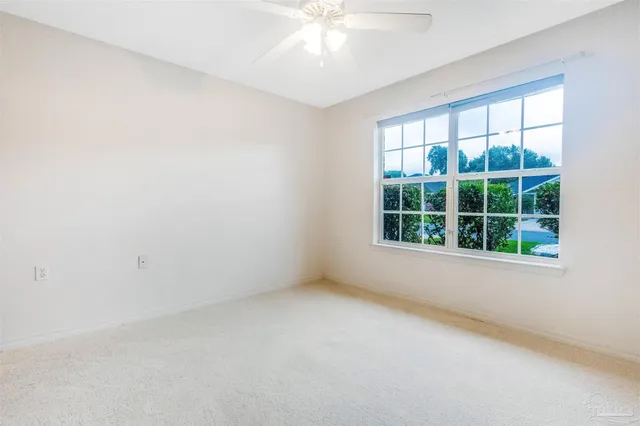 a view of empty room with wooden floor and window