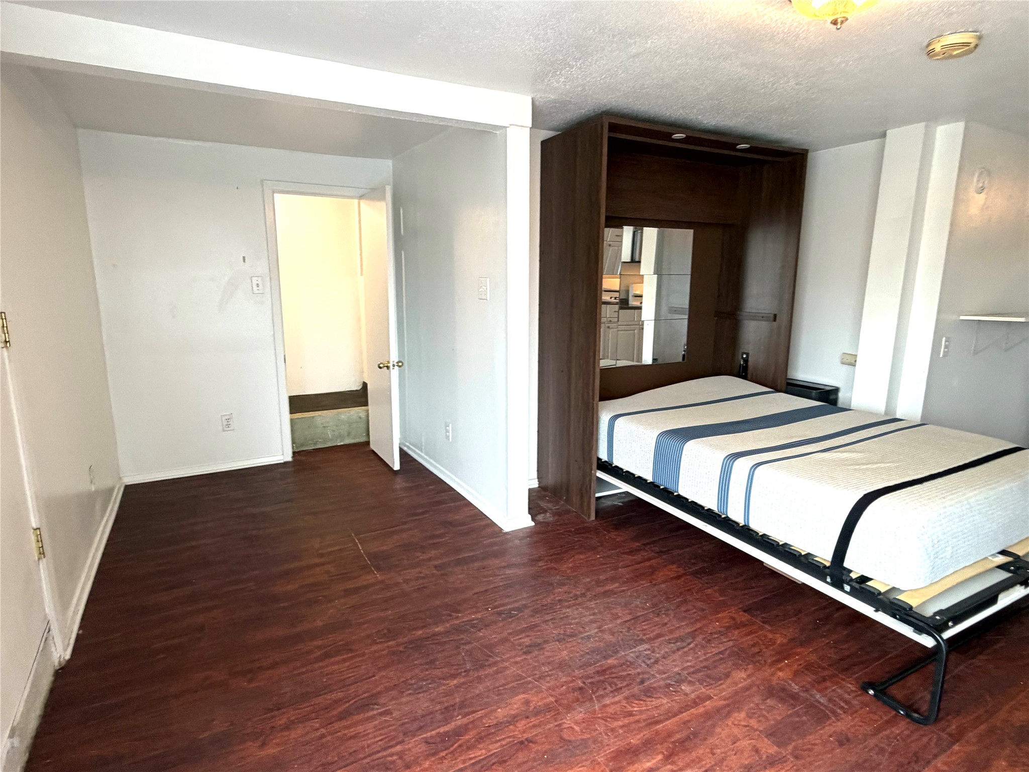 808 Edgecliff Terrace, Unit C Austin, TX 78704 - Photo 5 of 12 Bedroom with dark wood-type flooring and a textured ceiling