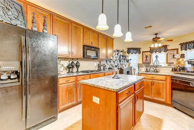 a kitchen with stainless steel appliances granite countertop a sink refrigerator and cabinets