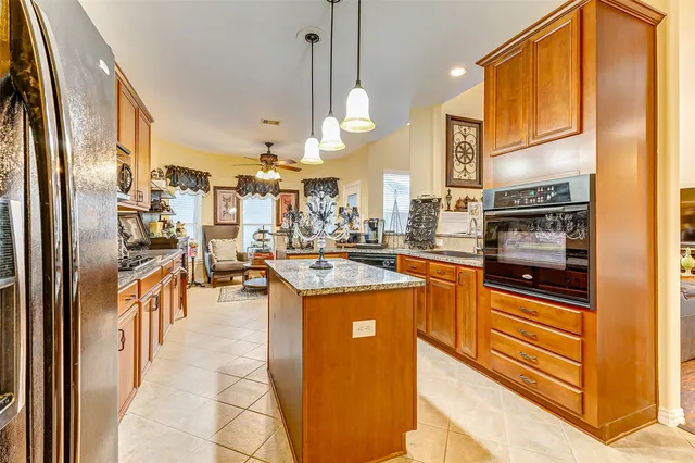 a kitchen with stainless steel appliances granite countertop a refrigerator a oven a stove and a sink