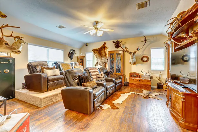 a living room with furniture kitchen view and a wooden floor
