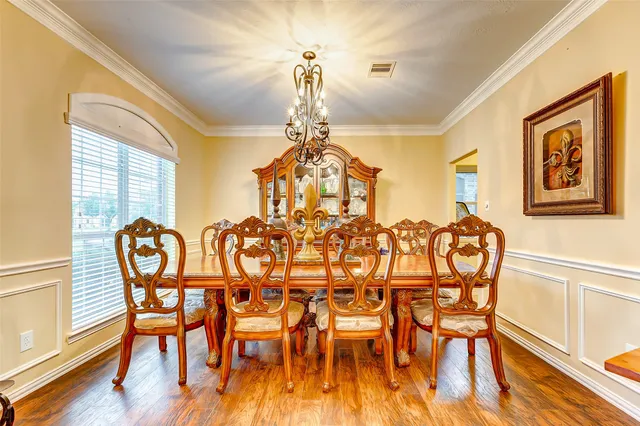 a dining room with furniture a chandelier and wooden floor