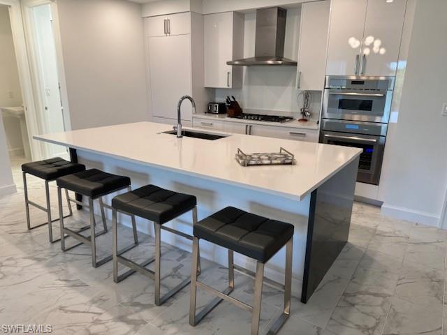 1125 Central Avenue, Unit 461 Naples, FL 34102 - Photo 4 of 19 a kitchen with stainless steel appliances kitchen island a table chairs in it and wooden floors