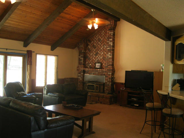 10786 Deschutes Road Palo Cedro, CA 96073 - Photo 2 of 24 a living room with furniture a flat screen tv and a floor to ceiling window