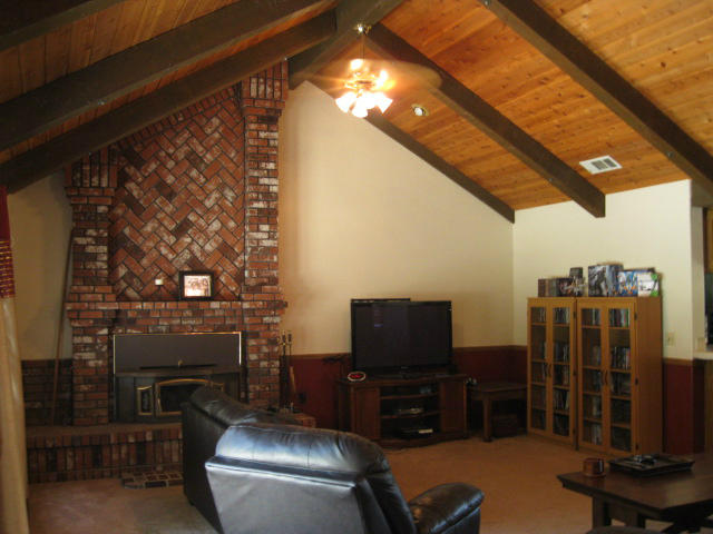 10786 Deschutes Road Palo Cedro, CA 96073 - Photo 3 of 24 a room with furniture a flat screen tv and a fireplace