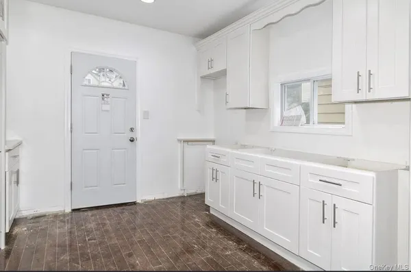 a kitchen with white cabinets and sink