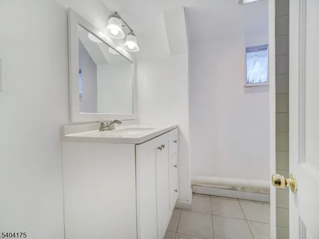 a bathroom with a sink a light fixture and a mirror