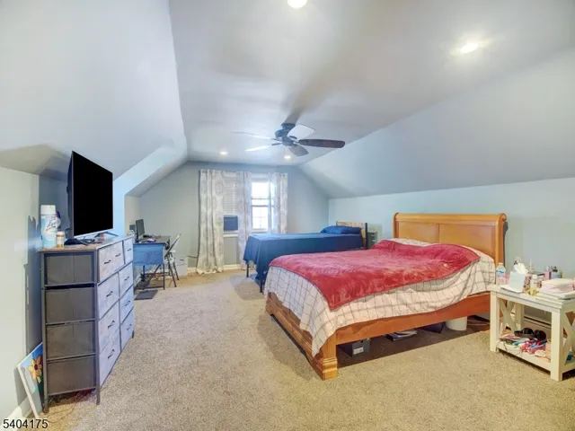 a spacious bedroom with a bed and a flat screen tv