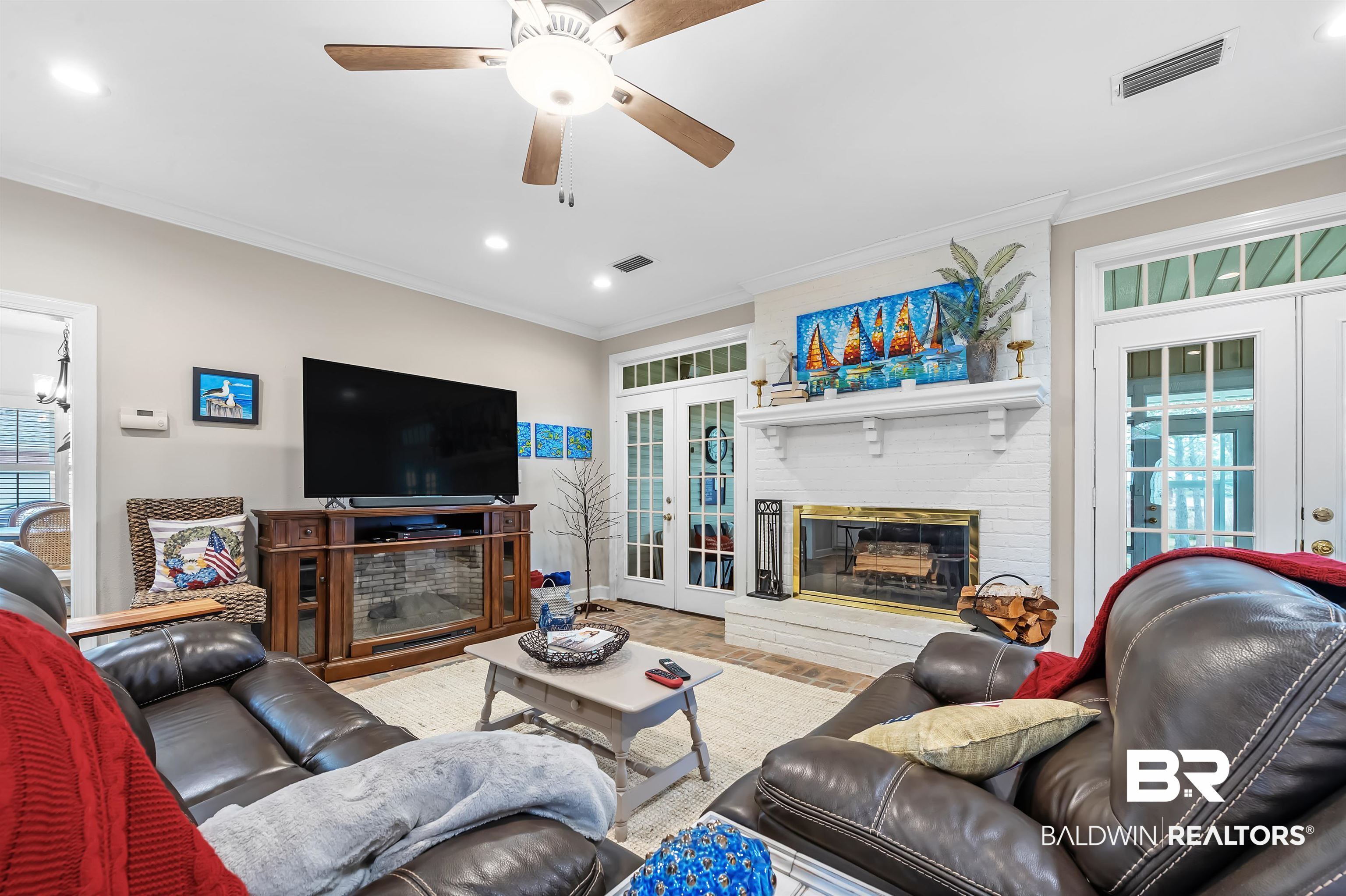 8915 Bay Point Drive Elberta, AL 36530 - Photo 12 of 74 Living area with french doors, a brick fireplace, visible vents, and crown molding