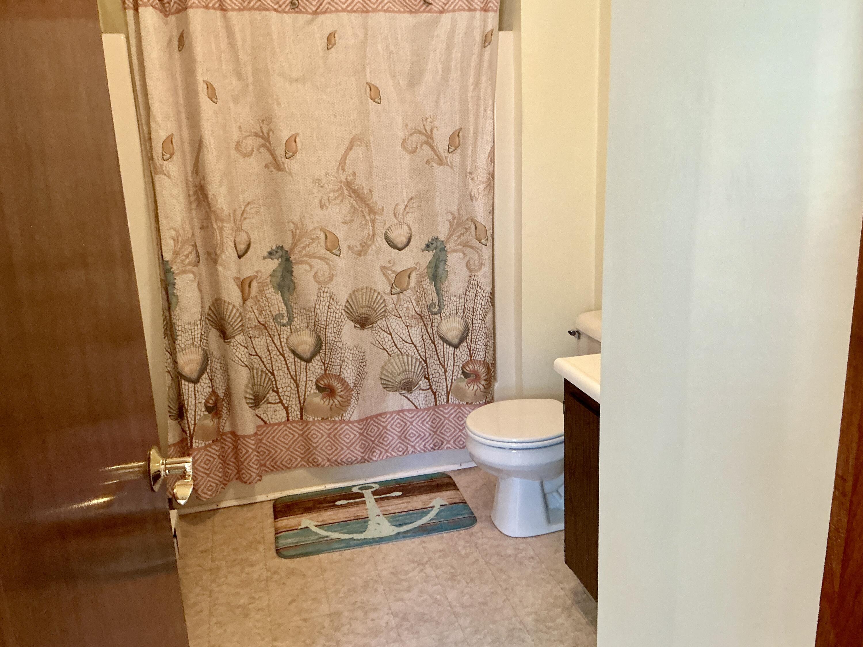 300 Falmouth Road, Unit 7E Mashpee, MA 02649 - Photo 14 of 27 a bathroom with a toilet and a shower curtain