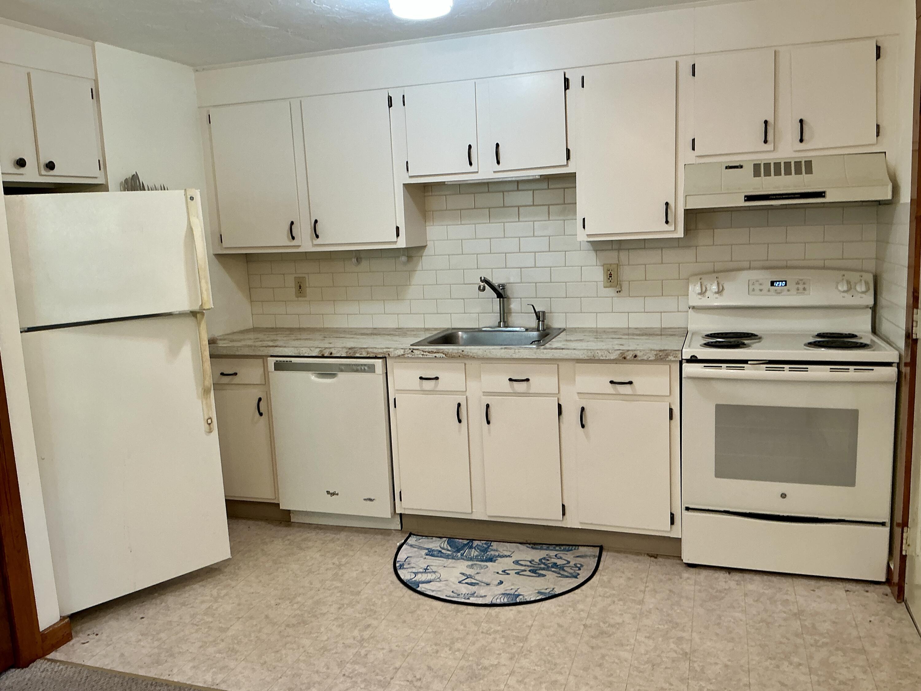300 Falmouth Road, Unit 7E Mashpee, MA 02649 - Photo 25 of 27 a kitchen with granite countertop a stove a sink and a refrigerator