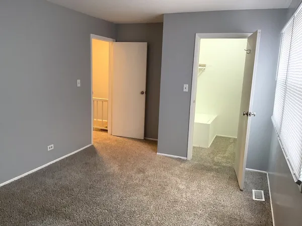 a view of an empty room with a fireplace and a window