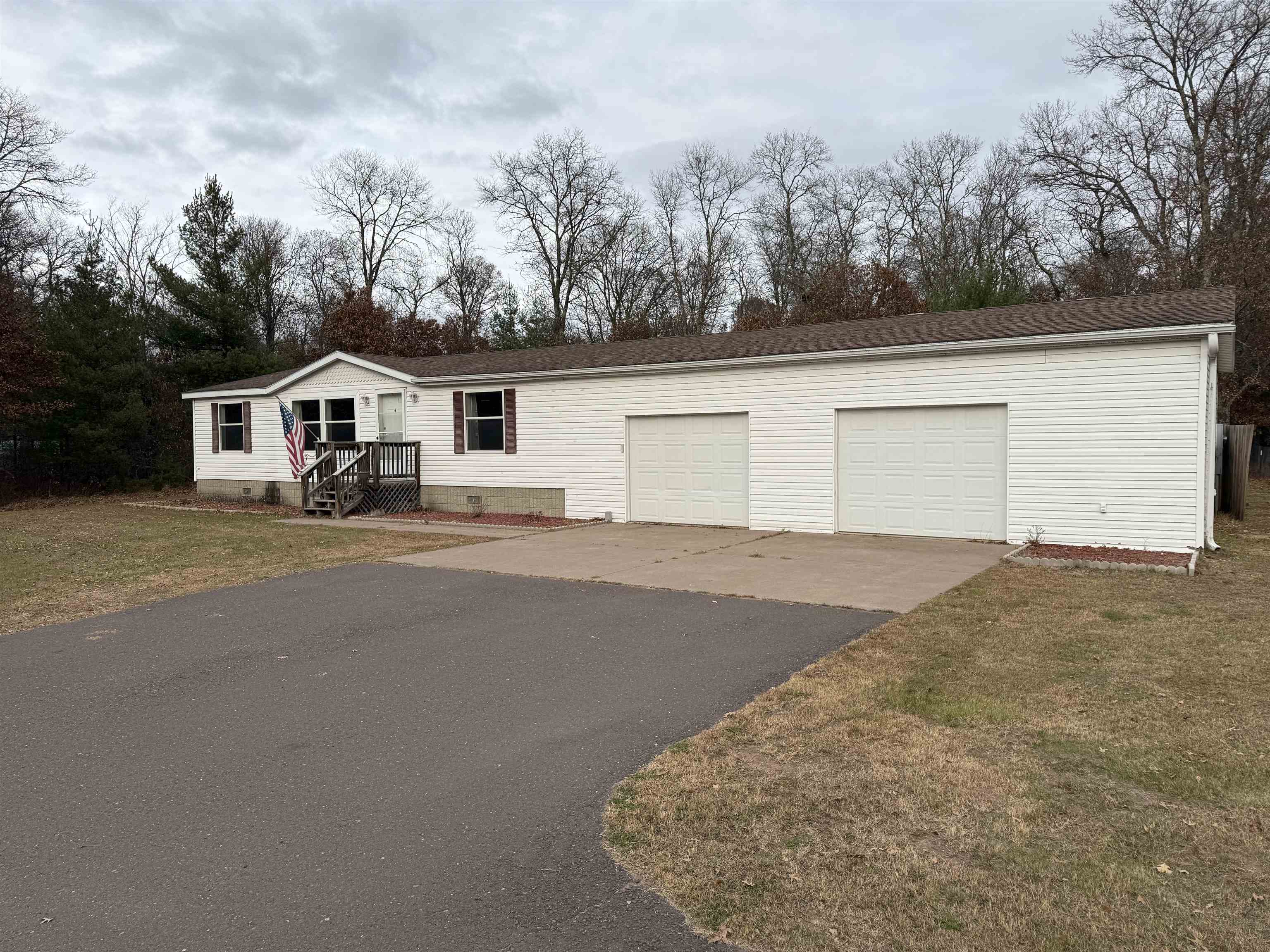 View of front facade with driveway, a front lawn, and a garage