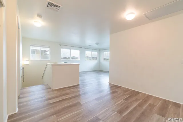 a view of a kitchen with wooden floor and a refrigerator
