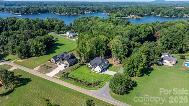 an aerial view of a house with a yard and lake view