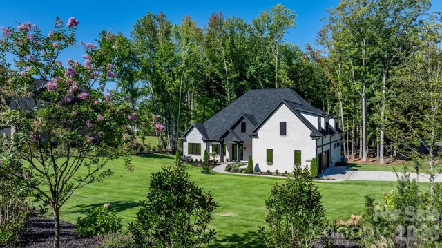 a backyard of a house with lots of green space and fountain