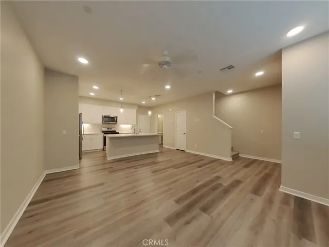 a view of an empty room with a kitchen