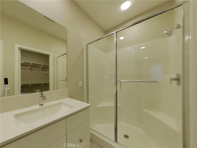 a bathroom with a shower sink vanity and mirror