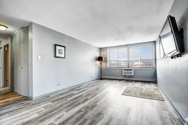 a view of a room with wooden floor cabinets and a kitchen