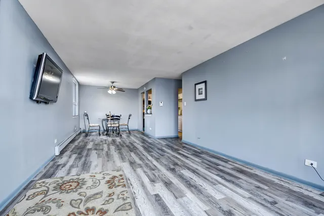 a view of a livingroom with wooden floor and furniture