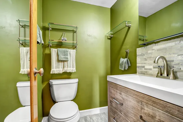 a bathroom with a toilet sink and mirror