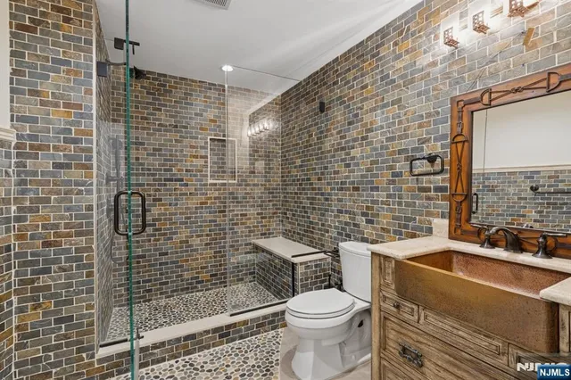 a bathroom with a sink a toilet and shower