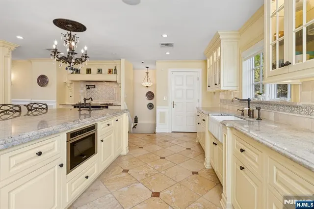 a large white kitchen with granite countertop a sink and cabinets