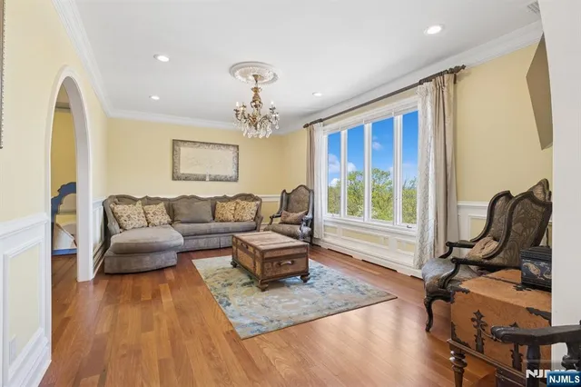 a living room with furniture a fireplace and a chandelier
