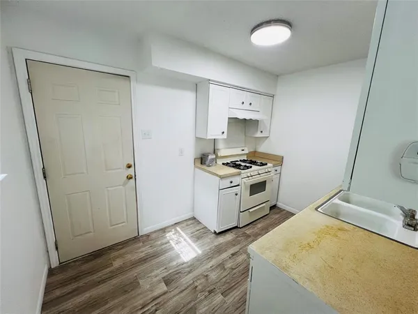 a kitchen with granite countertop a sink and a stove top oven