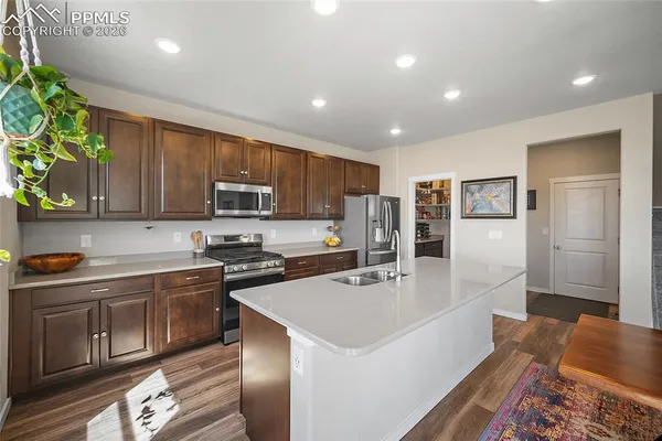 a large kitchen with stainless steel appliances granite countertop a sink a stove a refrigerator and cabinets