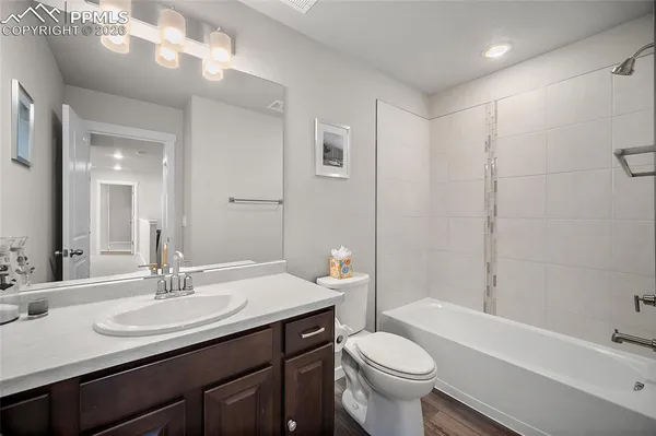 a bathroom with a sink a toilet a mirror and shower