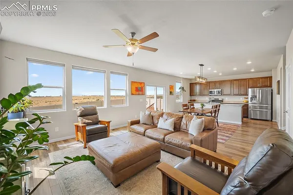 a living room with furniture kitchen view and a potted plant