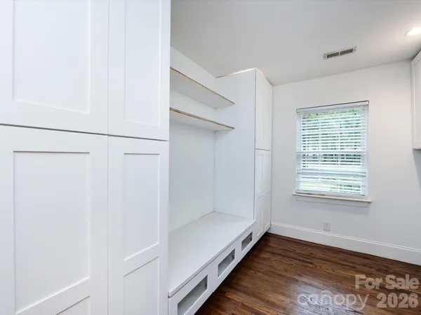 a kitchen with stainless steel appliances granite countertop a sink a window and wooden floor
