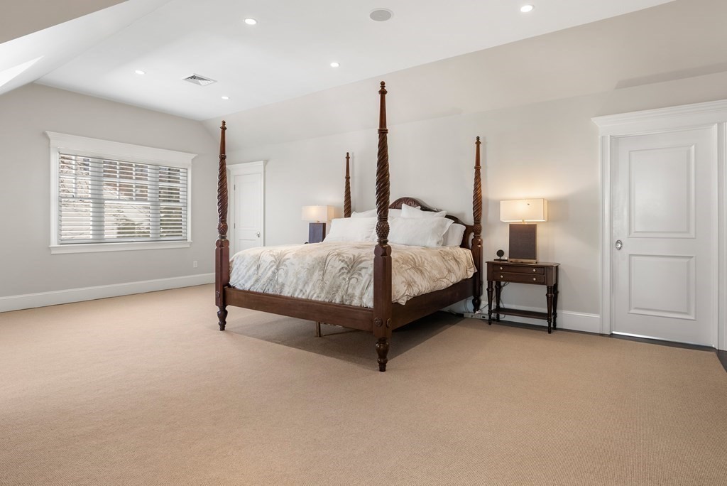 178 Lowell Road Wellesley, MA 02481 - Photo 21 of 38 a spacious bedroom with a bed lamp and a window