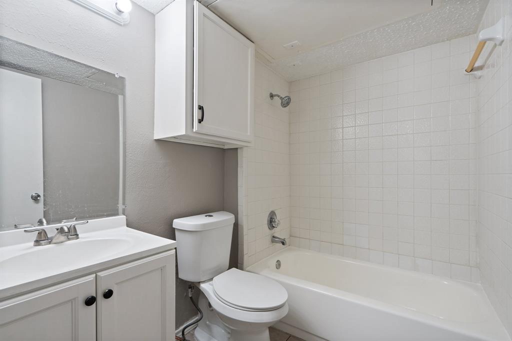 9831 Walnut Street, Unit 205 Dallas, TX 75243 - Photo 15 of 29 Full bathroom featuring a textured ceiling, vanity, toilet, and tiled shower / bath