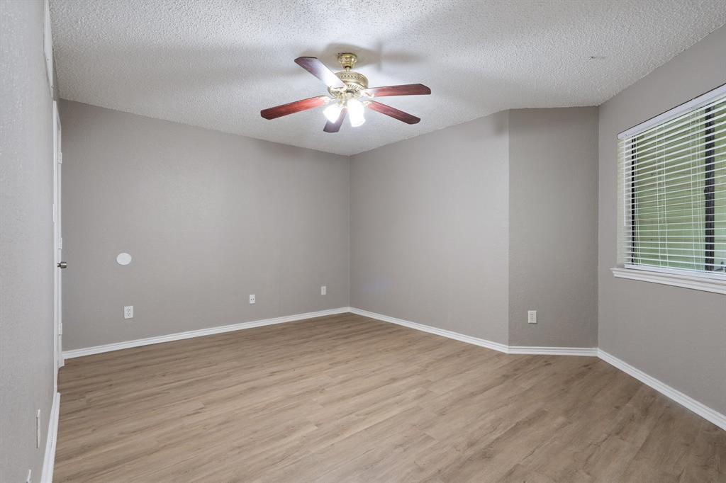 9831 Walnut Street, Unit 205 Dallas, TX 75243 - Photo 16 of 29 Spare room featuring ceiling fan, light hardwood / wood-style flooring, and a textured ceiling