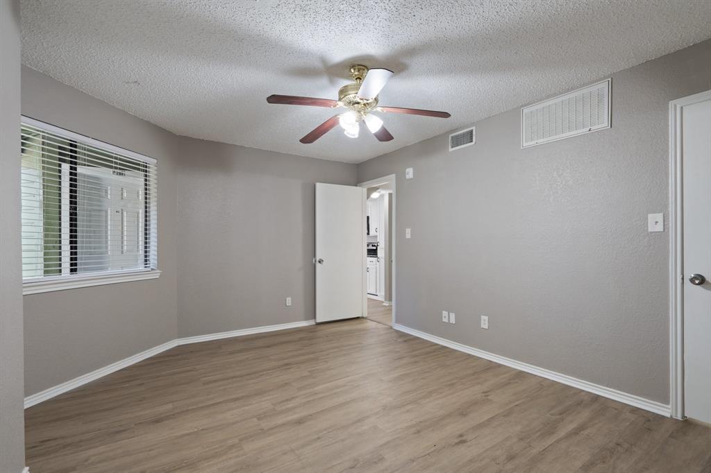 9831 Walnut Street, Unit 205 Dallas, TX 75243 - Photo 18 of 29 Unfurnished room with a textured ceiling, light hardwood / wood-style floors, and ceiling fan