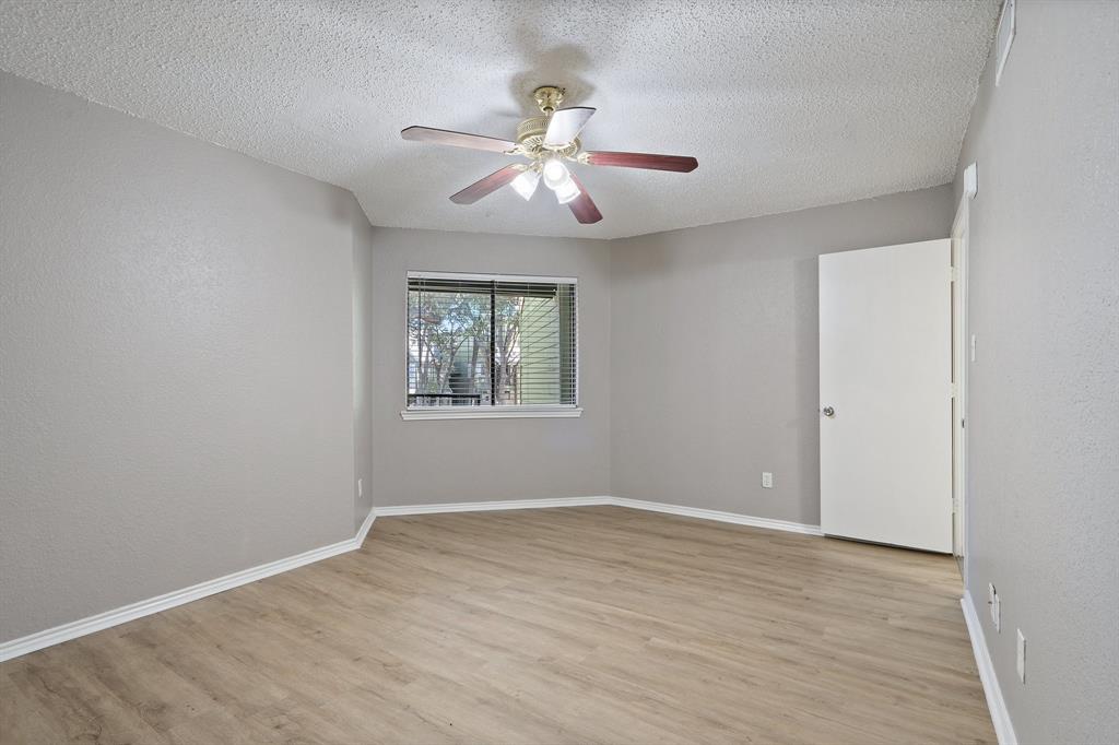 9831 Walnut Street, Unit 205 Dallas, TX 75243 - Photo 19 of 29 Spare room featuring ceiling fan, light hardwood / wood-style flooring, and a textured ceiling