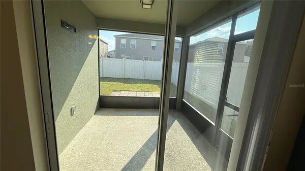 a view of backyard of house with wooden fence