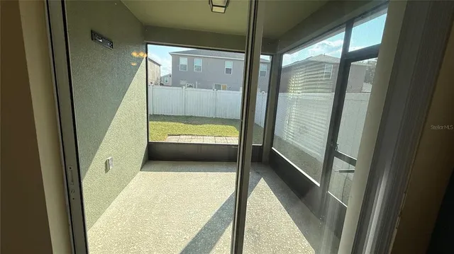 a view of backyard of house with wooden fence