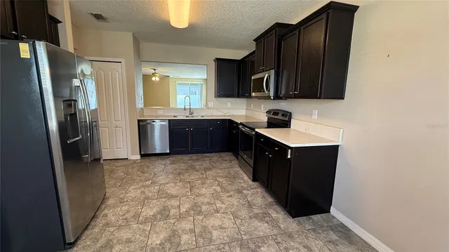 a kitchen with stainless steel appliances granite countertop a refrigerator and a sink