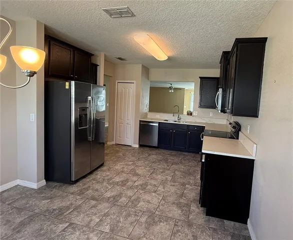 a kitchen with granite countertop a refrigerator and a sink